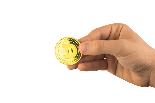 Um dogecoin dourado na mão, isolado no fundo branco, foto do conceito de pagamentos em criptomoeda