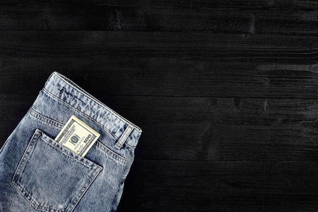 Um dólar de bolso no bolso de trás de uma calça jeans gasta, close-up