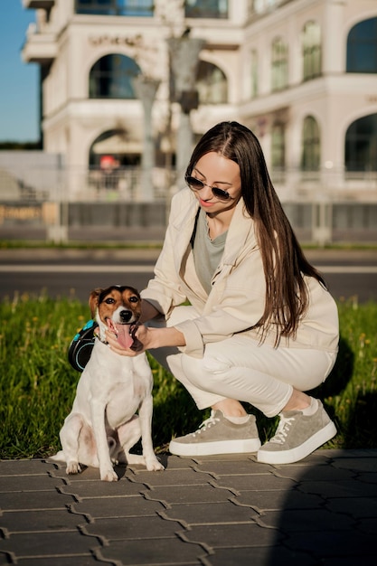 Um dono de cachorro atencioso. uma menina e seu animal de estimação na cidade