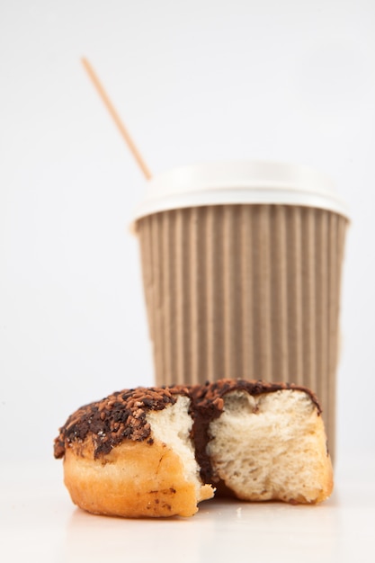 Um donut meio comido e uma xícara de café colocados juntos