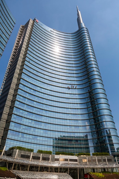 Um edifício com fundo de céu azul e um edifício com fachada de vidro.