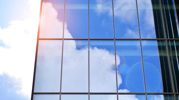 Foto um edifício com um céu azul e nuvens refletidas nele