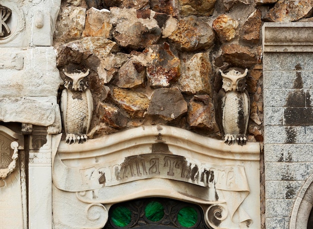 Um edifício de pedra com duas corujas no topo