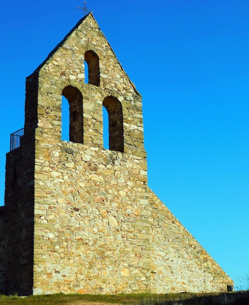 Um edifício de pedra com um céu azul ao fundo