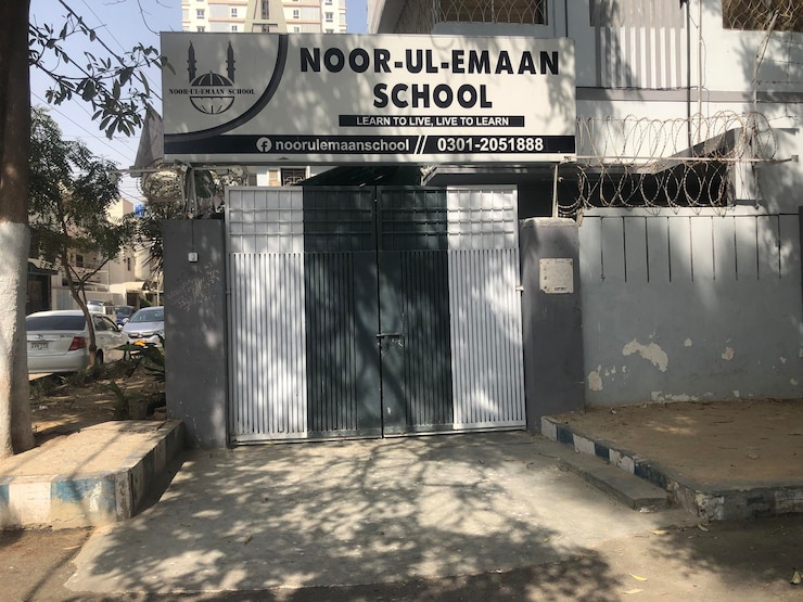 Foto um edifício escolar com uma placa que diz escola noor ul eman