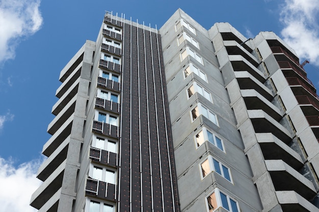 Um edifício residencial de painel moderno típico em construção. isolamento e acabamento da fachada.