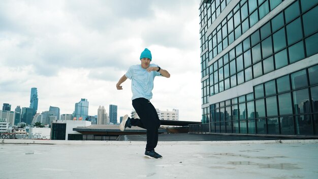 Foto um elegante homem caucasiano a dançar a fazer break dance no arranha-céu.