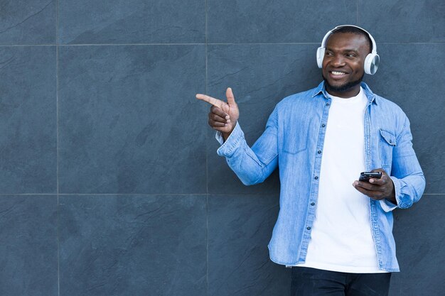 Um elegante jovem afro-americano ouve música em fones de ouvido