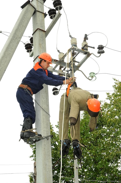 Um eletricista ajuda o trabalhador afetado por um choque elétrico. treinamento em um manequim.