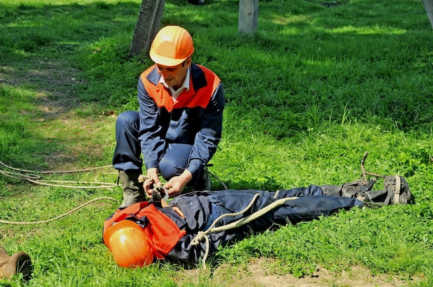 Um eletricista ajuda uma vítima de choque elétrico. Treinando em manequim.