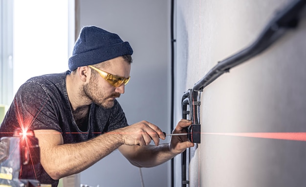 Um eletricista está montando tomadas elétricas na parede branca dentro de casa