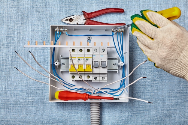 Um eletricista fixa os fios à régua de terminais para corrente neutra.