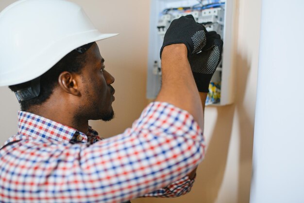 Foto um eletricista masculino trabalha em uma central elétrica com um cabo de conexão elétrica.