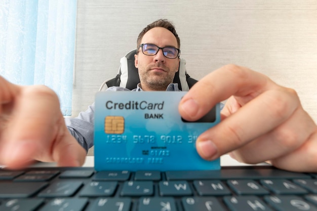 Um empresário alegre insere os detalhes do cartão de crédito para uma compra online Compras online de negócios e serviços bancários online Compras online de clientes pagam com cartão de crédito