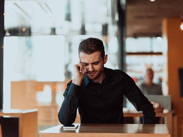 um empresário cansado sentado em um refeitório em uma pausa, uma dor de cabeça