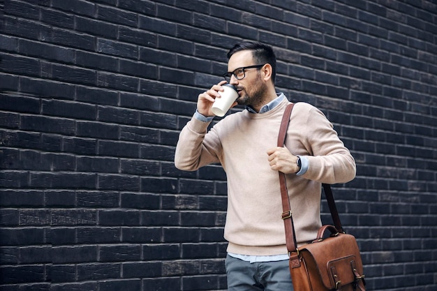 Um empresário casual bebe café para ir a caminho do escritório