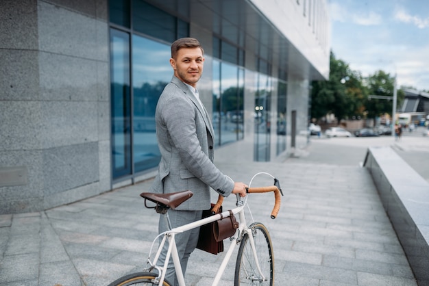 Um empresário com uma pasta andando de bicicleta no centro da cidade