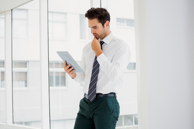 Um empresário está segurando e lendo um caderno