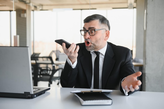 Um empresário frustrado a gritar com raiva ao telefone.