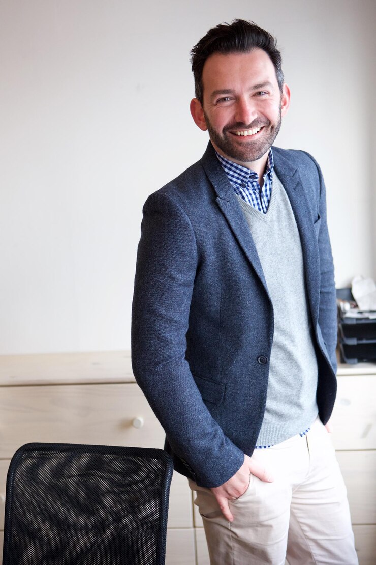 Um empresário sorridente de pé no escritório.