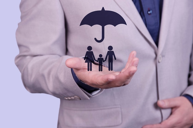 Foto um empresário tem um guarda-chuva na mão, sobre um conceito de família, para proteção, segurança, finanças e seguros. foto de alta qualidade