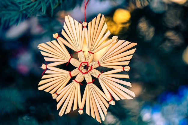 Um enfeite de natal feito de fósforos com uma fita vermelha.