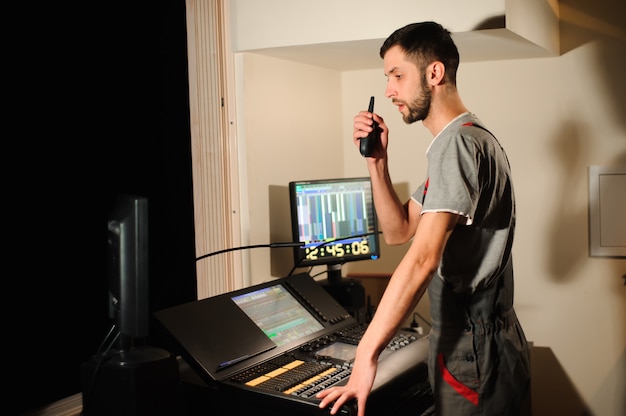 Um engenheiro de iluminação trabalha com o controle de técnicos de luzes no show de concertos. Misturador de luz profissional, console de mixagem. Equipamento para shows.