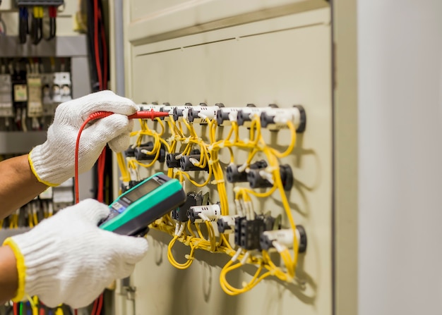 Um engenheiro elétrico testa o funcionamento do gabinete de controle elétrico