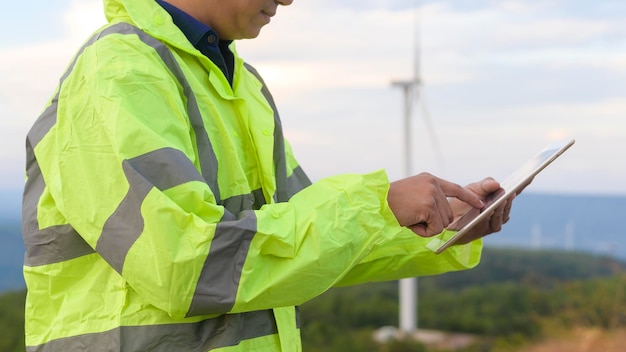 Um engenheiro homem está usando um capacete protetor na cabeça usando o tablet Analytics