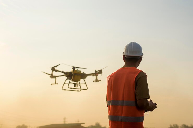 Um engenheiro masculino controlando drones pulverizando fertilizantes e pesticidas sobre terras agrícolas