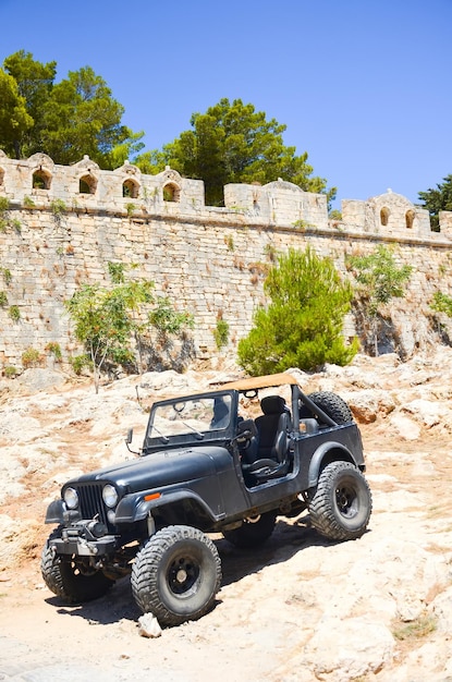 Um enorme jipe preto perto da antiga fortaleza em Rethymno