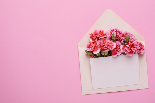 Um envelope com flores cor de rosa e um cartão de presente em rosa