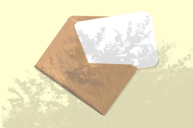 Um envelope com uma folha de papel branco texturizado sobre um modelo de fundo de mesa amarelo com uma sobreposição de