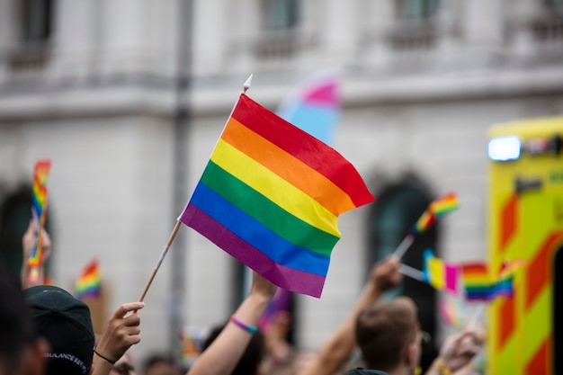 Um espectador agita uma bandeira de arco-íris gay em uma marcha do orgulho gay lgbt em londres