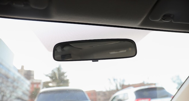 Um espelho retrovisor está acima do pára-brisa do carro.