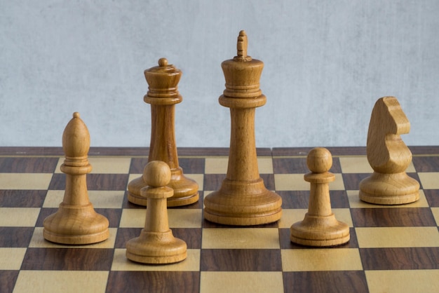 Um esquadrão de figuras de xadrez branco no tabuleiro de xadrez