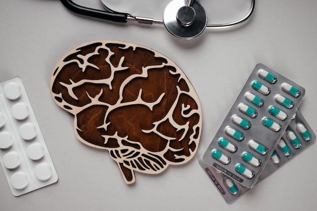 Um estetoscópio e um cérebro com pílulas Consciência aproximada da doença de Alzheimer, doença de Parkinson, demência, acidente vascular cerebral, convulsão ou saúde mental