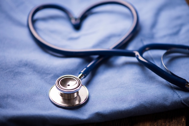 Um estetoscópio moldando um coração em um uniforme médico, closeup