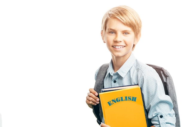 Um estudante de inglês sorridente com uma mochila e livros iluminados pelo sol