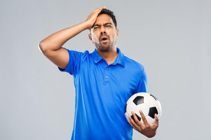 Foto um fã de futebol indiano com uma bola de futebal.