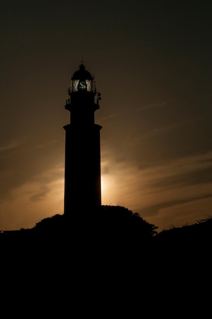 Um farol ou torre de sinalização luminosa localizada na costa marítima ou no continente