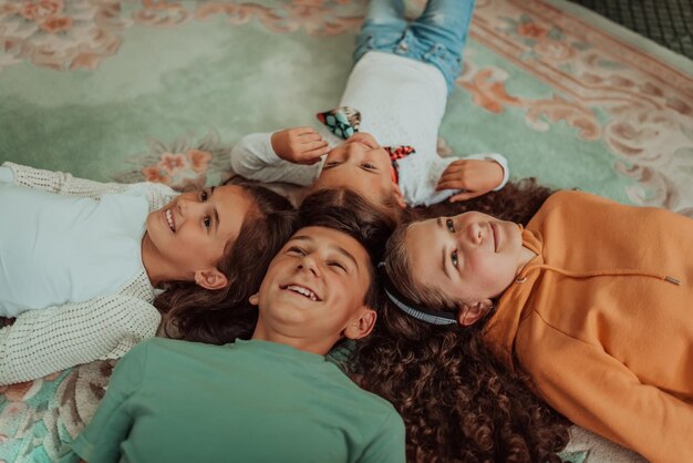 Um feliz grupo de amigos está deitado no chão em um círculo de cabeças unidas Foco seletivo Foto de alta qualidade