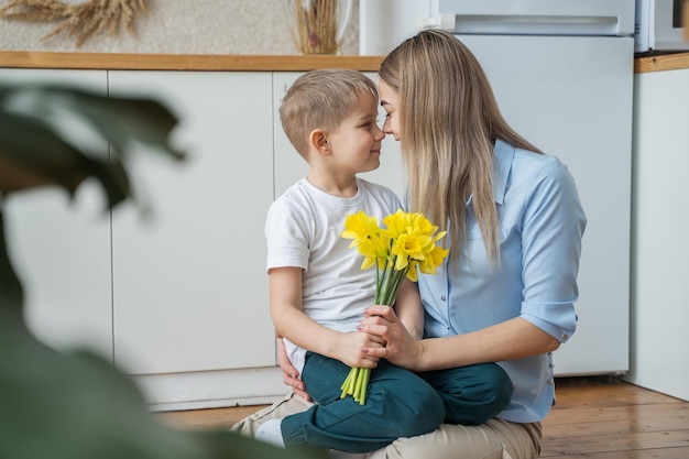 um filho pequeno dá flores para sua mãe o menino felicita sua mãe em 8 de março