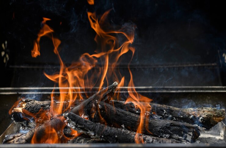 Um fogo quente em um churrasco em um fundo preto conceito de churrasco de verão