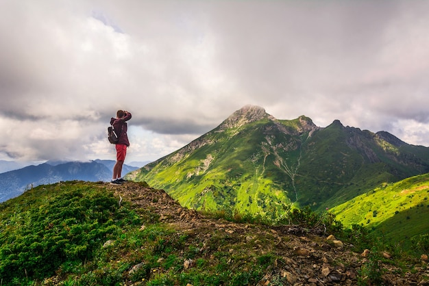 Um fotógrafo está tirando fotos de uma das montanhas de Aibga Ridge Sochi perto de Rosa Khutor