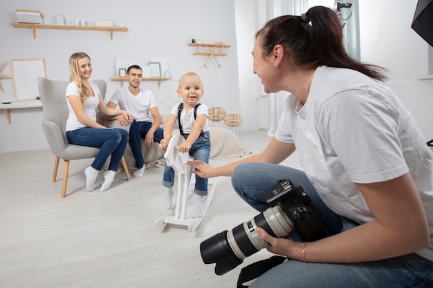 Um fotógrafo fotografa uma família em um estúdio fotográfico.