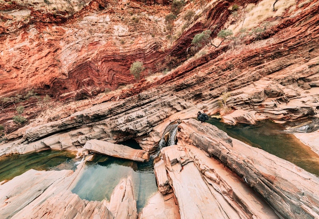 Um fotógrafo masculino fotografando formas diagonais e curvas de hamersley gorge, karijini.