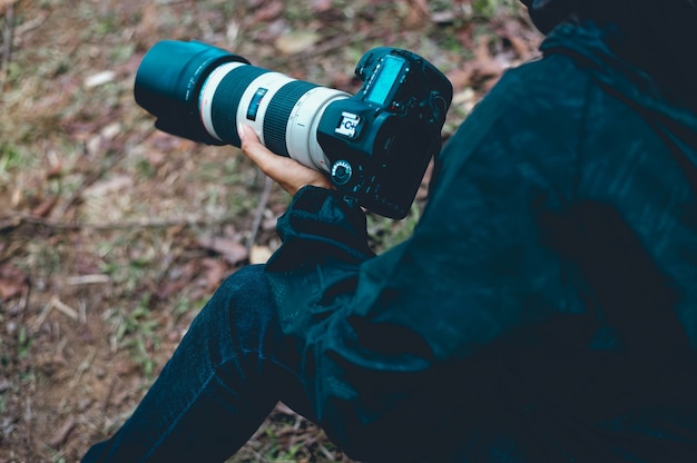 Um fotógrafo segura uma câmera, prepara uma fotografia de várias tarefas