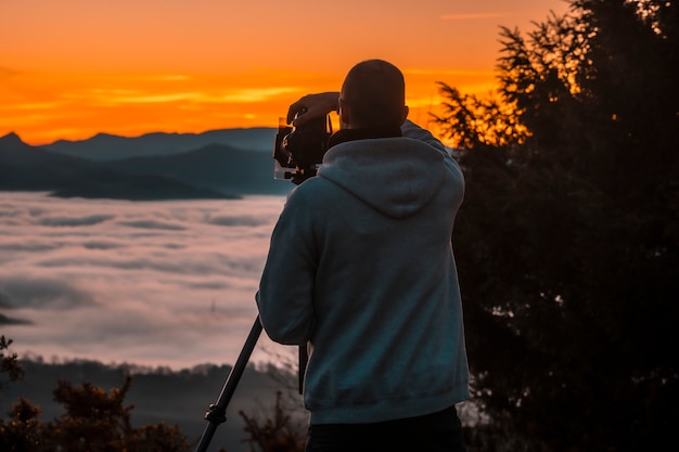 Um fotógrafo tirando o nevoeiro em uma manhã de inverno