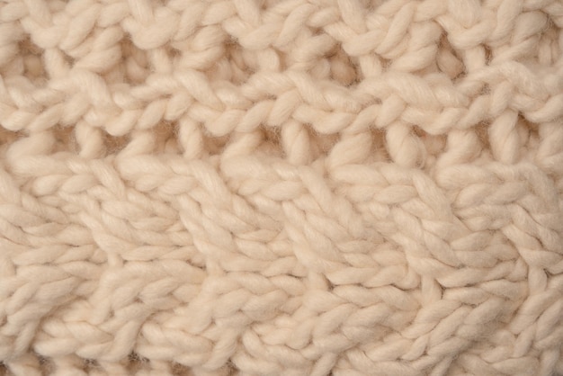 Um fragmento de tecido de malha bege feito de lã de ovelha branca
